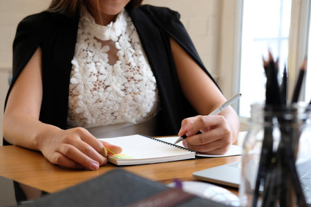 woman writing reminder schedule note on notebook. businesswoman working organizing plan at workplace...