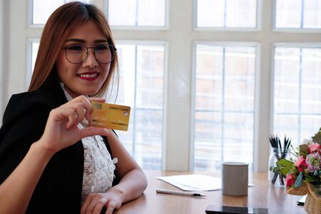 smiling asian woman with credit card for shopping online.の写真素材