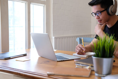 man college student  studying learning lesson with computer online & taking note
