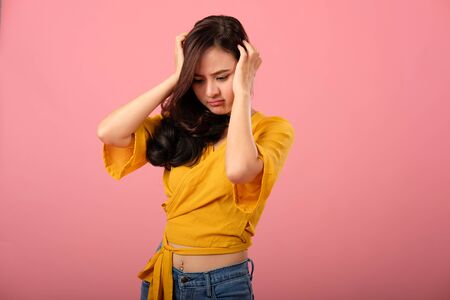 studio portrait of asian woman in casual clothing feeling sad unhappy stressed depressedの写真素材