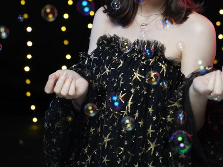 woman in black evening dress with bubble & yellow bokeh
