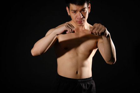 portrait of athletic muscular bodybuilder man with naked torso six pack abs boxing punching. fitness workout conceptの写真素材