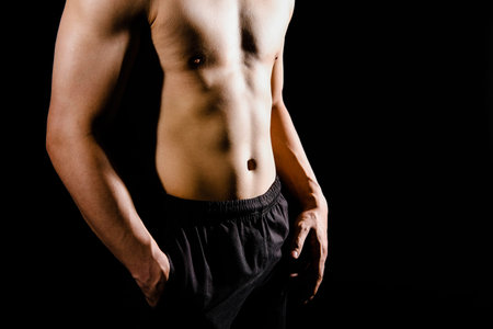 portrait of athletic muscular bodybuilder man with naked torso six pack abs. fitness workout concept