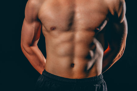 portrait of athletic muscular bodybuilder man with naked torso six pack abs. fitness workout concept