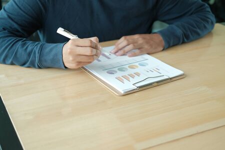 startup male freelancer working with document at office. man entrepreneur analyzing financial performance at workplace. student studying doing assignmentの写真素材