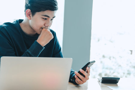 male freelancer using mobile smart phone. startup man entrepreneur working at workplace.