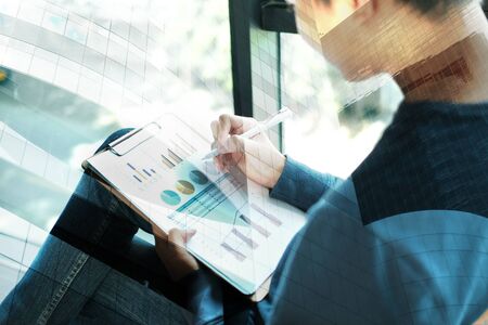 startup male freelancer working with document at office. man entrepreneur analyzing financial performance at workplace. student studying doing assignmentの写真素材