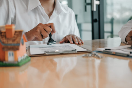 real estate agent using stamper for stamping approved on mortgage loan contract agreement document