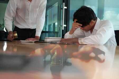 lawyer giving advice to a man. businessman discussing legal legislation at law firm. judge team meeting at courtroomの写真素材