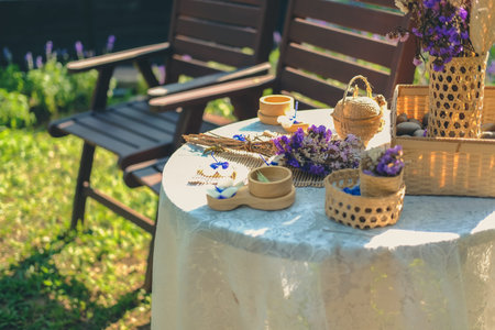 purple flower, candle & wicker basket decorating on table in garden