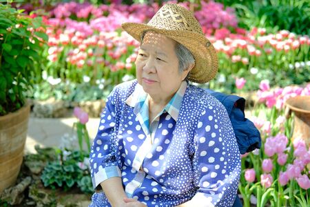old elder woman resting in garden. asian elderly female relaxing outdoors. senior leisure lifestyleの写真素材