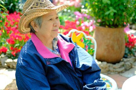 old elder woman resting in garden. asian elderly female relaxing outdoors. senior leisure lifestyleの写真素材