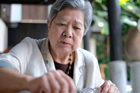 old elderly senior elder woman eating food at restaurant. mature retirement lifestyleの写真素材