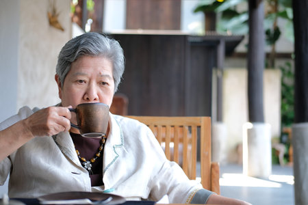 old elderly senior elder woman drinking coffee tea at restaurant. mature retirement lifestyleの写真素材