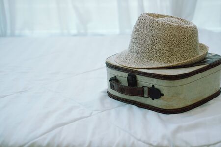 bag baggage luggage hat on white bed mattress. travel trip journeyの写真素材