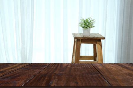 plant pot on wooden bar stool chair beside see through sheer window curtain