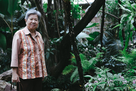 old elder woman wearing facial medical mask resting in garden. asian elderly senior relaxing...