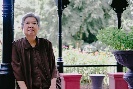 asian elder female woman resting relaxing on balcony terrace at home. elderly senior leisure lifestyleの写真素材