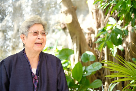 elder woman resting in garden. asian elderly female relaxing outdoors. senior leisure lifestyle