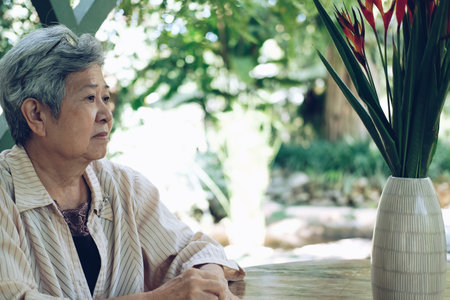 elder woman resting in garden. asian elderly female relaxing outdoors. senior leisure lifestyle