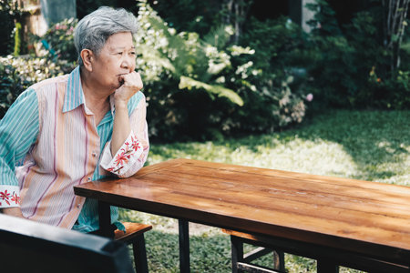 elder woman resting in garden. asian elderly female relaxing outdoors. senior leisure lifestyleの写真素材