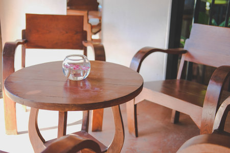 glass bowl with flower floating on water decorating on wooden table in living room at homeの写真素材