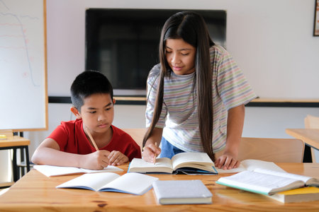 asian boy girl student studying writing notes doing homework in library. learning education at...
