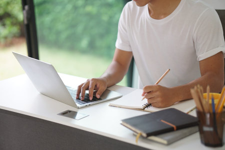asian young teenage student man teenager entrepreneur working with computer writing note studying...