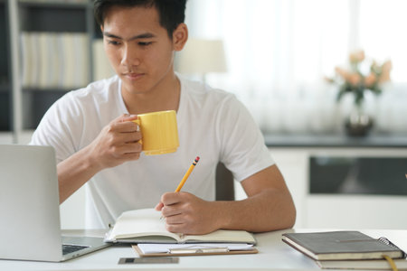 asian young teenage student man teenager entrepreneur working with computer writing note studying...