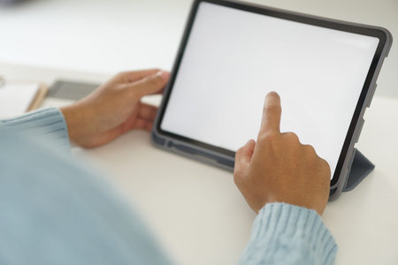hand touching white blank screen of digital tablet at home workplace