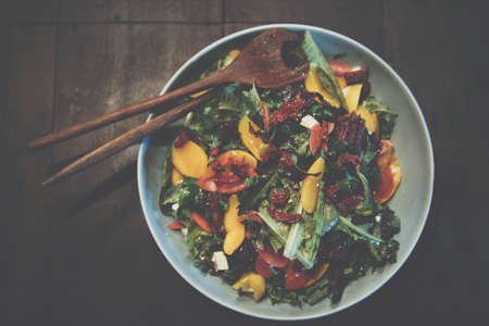 mixed vegetable salad with olive oil on wooden tableの写真素材