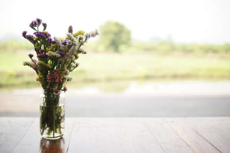 flower bouquet in glass vase on wooden table at patioの写真素材