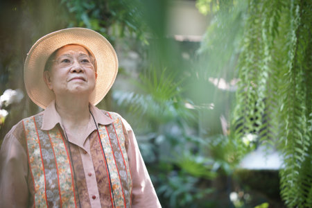 asian old elderly female elder woman resting relaxing in garden. senior leisure lifestyleの写真素材