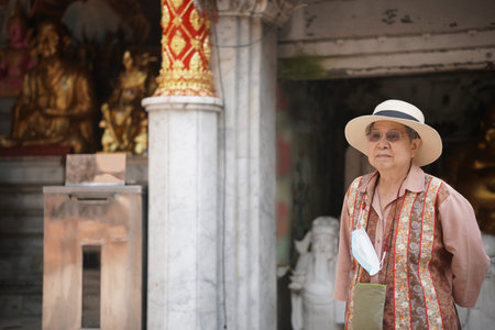 old elderly female elder woman traveller traveling in asian temple. senior leisure lifestyle