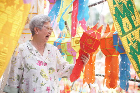 asian old elderly elder woman with hanging decorative festive paper lanternの写真素材