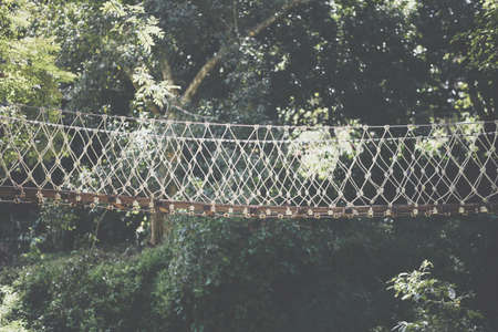 wooden hanging suspended rope bridge in garden parkの写真素材