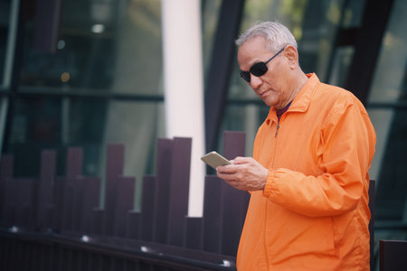 asian old elder senior man elderly using mobile smart phone cellphone outdoor. mature retirement...