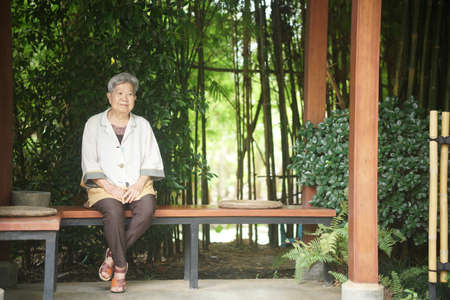 old elderly elder senior woman resting relaxing sitting in gardenの写真素材