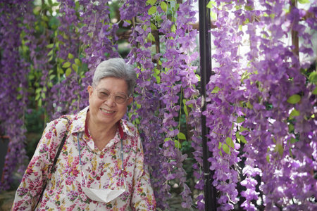 old elderly elder senior woman resting relaxing walking in gardenの写真素材