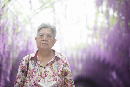 old elderly elder senior woman resting relaxing walking in gardenの写真素材