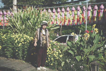 old elderly elder senior woman resting relaxing walking in flower gardenの写真素材