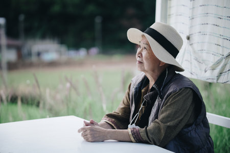 old elderly elder senior woman resting relaxing sitting in garden parkの写真素材
