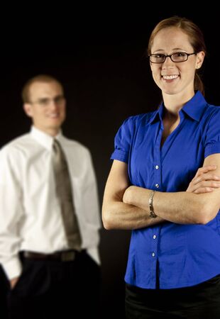 A attractive business woman in the foreground, with a business man in the backgroundの写真素材