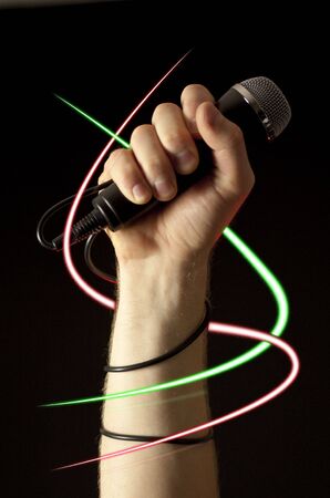 A hand with a microphone surrounded by sparkle trailsの写真素材