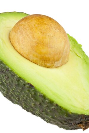 An avocado freshly cut in half, with the seed still insideの写真素材