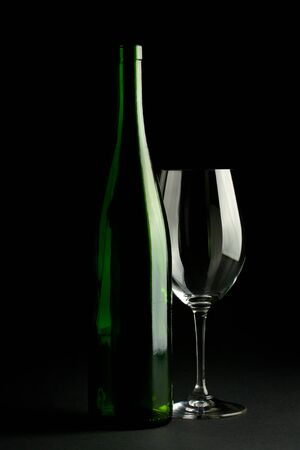 green wine bottle and a wine glassの写真素材