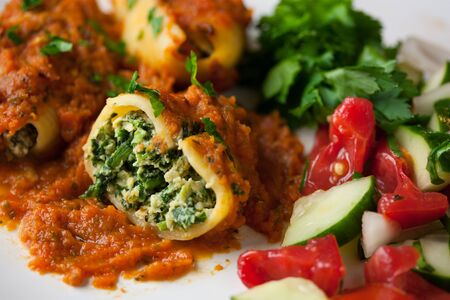 Vegan stuffed shells with a side of fresh organic vegetablesの写真素材