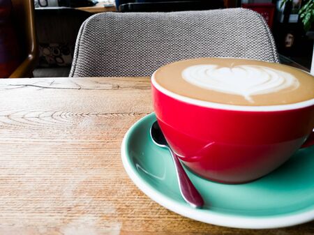 A red cup of coffee on wooden tableの写真素材