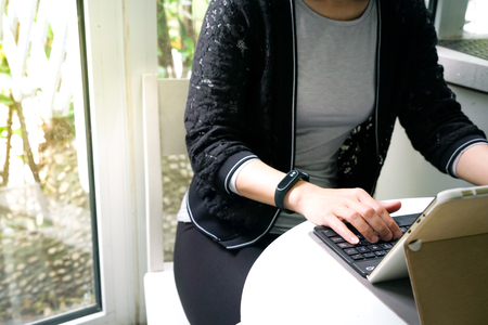 Young student women wearing smart band using tablet computerの写真素材
