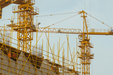 A crane is working on building construction siteの写真素材